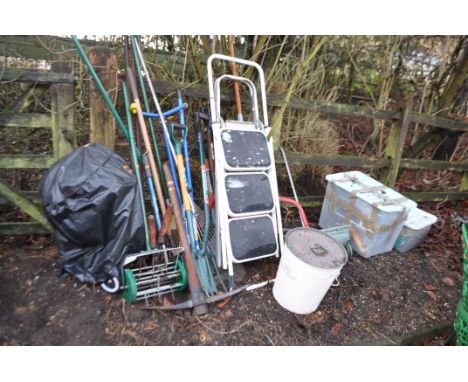 A SELECTION OF GARDEN TOOLS AND A BARBECUE including step ladders, rakes, forks,  lawn seeder, a bird seed buckets etc