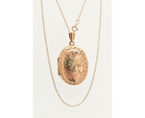 A 9CT GOLD OVAL LOCKET WITH CHAIN, foliate detailed oval locket, opens to reveal two vacant compartments suspending a small d