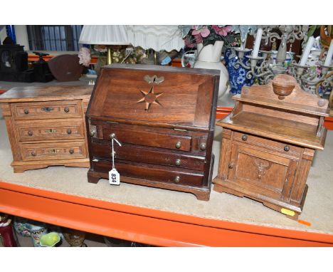 A MINIATURE WRITING BUREAU AND TWO MINIATURE SETS OF DRAWERS comprising a wooden miniature bureau with a fold-out writing slo