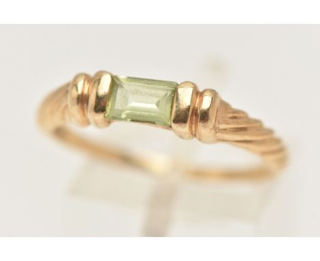 A 9CT GOLD GEM SET RING, set with a light green rectangular cut stone possibly spinel, tension set to the stepped and twist d