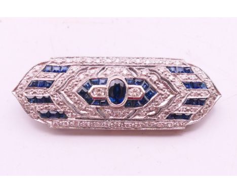 An 18 K white gold diamond and sapphire Art Deco-style brooch. 4 cm wide.