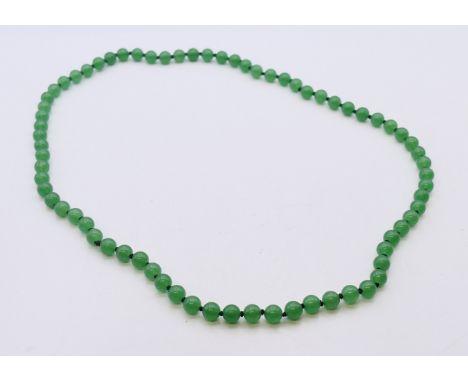 A string of small jade beads. 66 cm long.