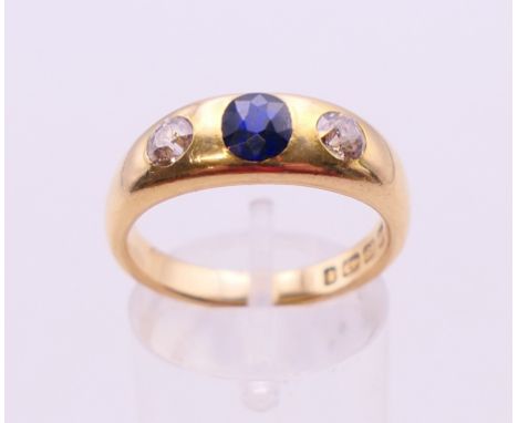 An 18 ct gold diamond and sapphire three-stone ring. Ring size P/Q.