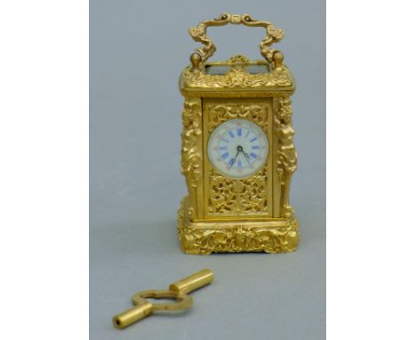 A cast gilt bronze mini carriage clock. 8.5 cm high.