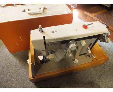 A CASED VINTAGE NEW HOME SEWING MACHINE