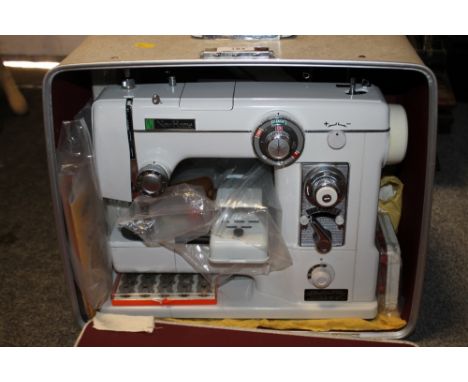 A CASED VINTAGE NEW HOME SEWING MACHINE