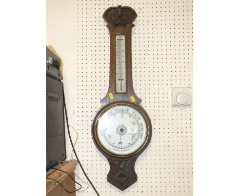 A CARVED OAK ANEROID BAROMETER