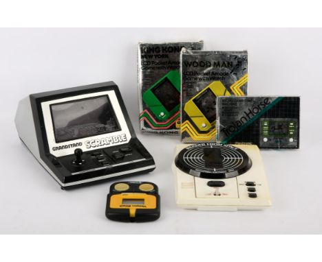 An assortment 1980s peripherals, power supplies and handheld console Includes: Grandstand Scramble, Invader from Space, Troja