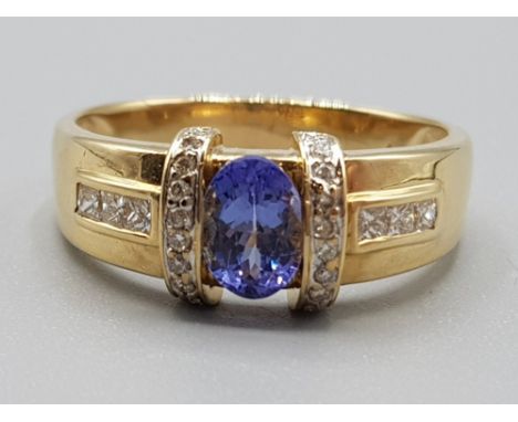 18ct yellow gold tanzanite &amp; diamond ring comprising of a oval tanzanite stone set in the centre with 3 princess cut diam