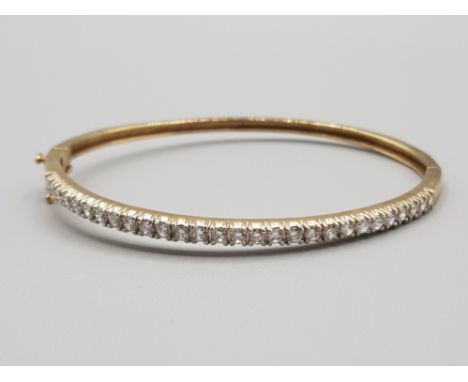 Ladies 9ct yellow gold cubic zirconia set bangle, set with round cut cubics set across the top of bangle, 10g gross