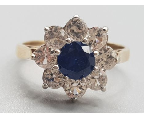 Ladies 9ct yellow gold blue &amp; white stone ring, set with a blue stone in the centre surrounded by 8 cubic zirconias, all 