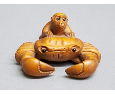 Finely carved hardwood netsuke depicting monkey on crabs back