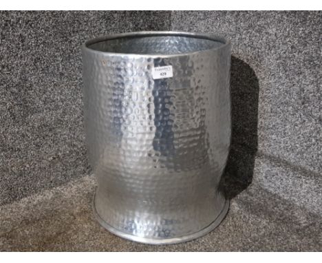 A hand beaten effect metal planter 43cm high.