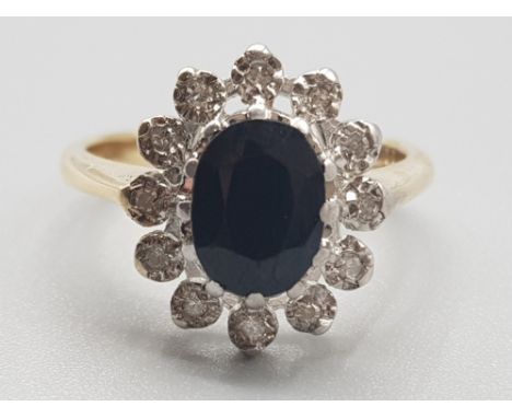 Ladies 9ct yellow gold sapphire &amp; diamond cluster ring, comprising of a oval black sapphire in the centre surrounded by 1