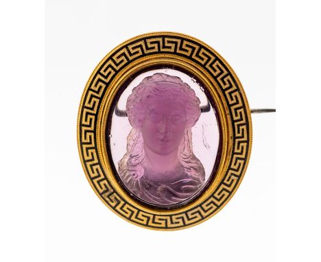 A late 19th century gilt metal and amethyst glass cameo brooch, the centre amethyst glass depicting a bust of a classical fem