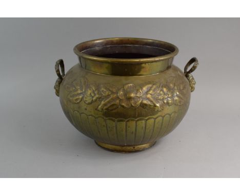 A Circular Brass Planter with Embossed Floral Swag decoration in Relief and Two Devil Mask Handles. 30cms Diameter 