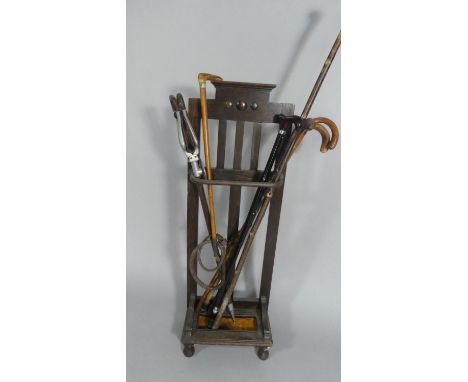 An Art Deco Oak Stick Stand Containing Riding Crop, Walking Sticks, Shooting Stick and Antler Thumb Stick. Metal Drip Tray 