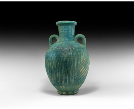 3rd century BC-2nd century AD. A glazed ceramic jar with flared foot, linear bands to the body and shoulders, broad tubular n
