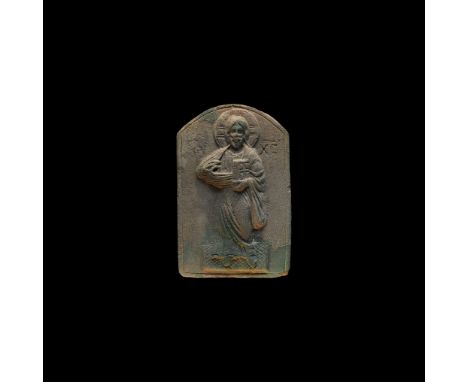 11th-12th century AD. An unglazed ceramic D-shaped plaque with incised border, low-relief figure of Christ standing on a hatc