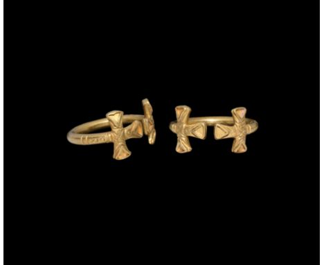 7th-8th century AD.. A gold penannular finger ring, each finial an expanding-arm cross with pellet detailing, each arm with t