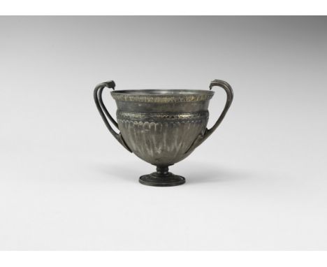 2nd-1st century BC. A silver bell-shaped skyphos with ribbed body, gilt circumferential frieze depicting two opposing wreaths