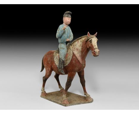 Tang Dynasty, 618-906 AD. A finely modelled ceramic figurine of a horse and rider on a quadrilateral base; the horse with tex