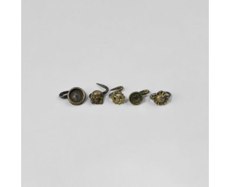 16th century AD. A mixed group of five silver pins each a plaque with S-shaped shank; designs include a facing mask, heart, r