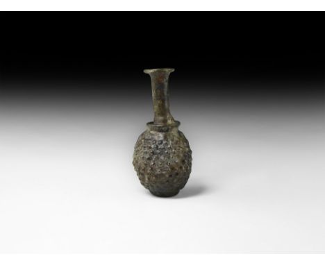 East Mediterranean, 2nd century AD. An aubergine-coloured glass flask with ovoid body carination to the shoulder, slender nec