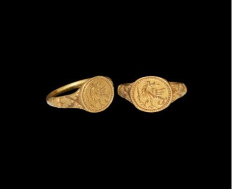 15th century AD. A gold finger ring with leaf detailing to the shoulders, discoid bezel with beaded border, intaglio cockatri