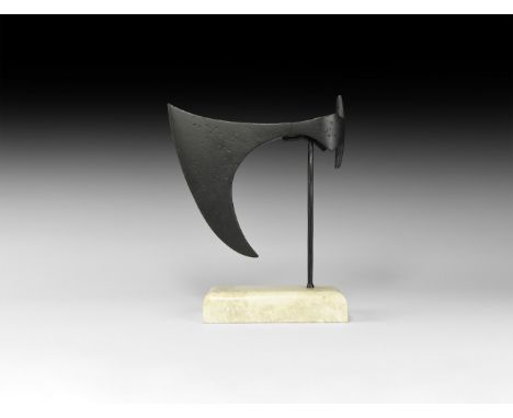 9th-11th century AD. An iron axehead with long, deeply curved blade, short neck, round socket with triangular wings above and