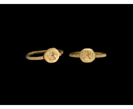 6th-8th century AD. A slender gold finger ring with facetted shoulders, disc bezel with nimbate bust of Christ(?) flanked by 