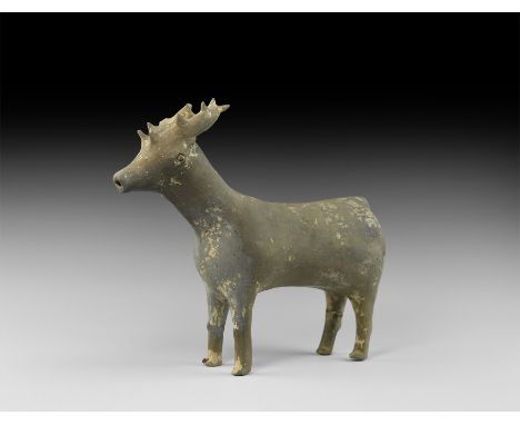 12th-10th century BC. An unglazed ceramic vessel formed as a standing stag with spurs to the antlers; filler hole to the neck