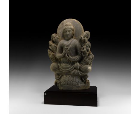 3rd century AD. A carved schist stele depicting Buddha seated on a lotus-leaf dais, nimbus to the rear and six small nimbate 