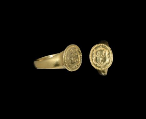 16th century AD. A gold Tudor Period finger ring with D-section hoop, disc bezel with beaded rim and ornate shield with three