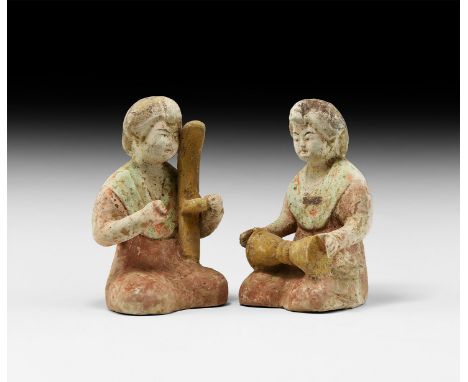 Tang Dynasty, 618-906 AD. A pair of glazed ceramic musician figures sitting cross-legged wearing a robe with open neck, one w