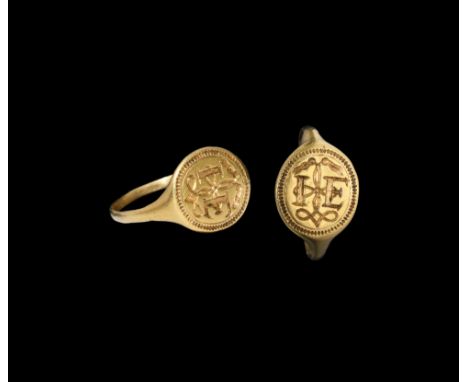 16th century AD. A D-section gold hoop with expanding shoulders, discoid bezel with beaded border, initials 'I E' over a loop