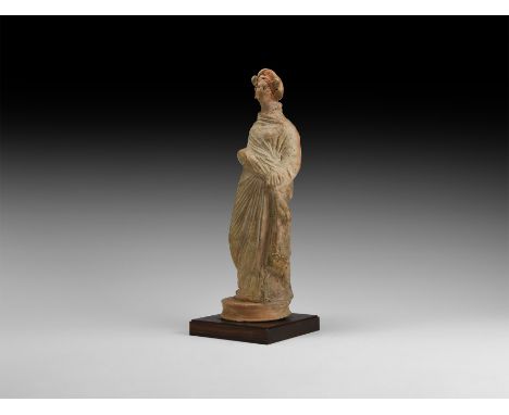 South Italian, 1st century BC. A hollow-moulded ceramic figurine with white slip coating and red detailing depicting a standi