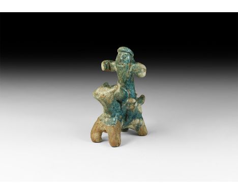 12th-14th century AD. A blue-glazed ceramic figure of a horseman with arms extended, annular cap above pellet eyes and slit m