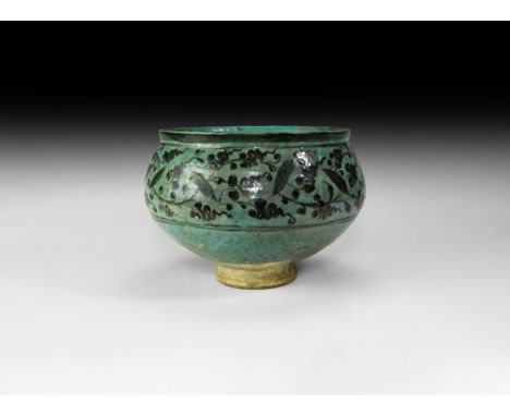 14th-16th century AD. A turquoise blue glazed ceramic footed bowl with scooped rim, band of black scrolled tendrils and folia