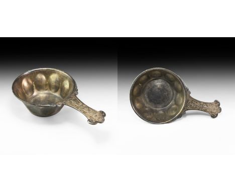 2nd-1st century BC. A silver patera with deep bowl and rolled rim, flat base and impressed bosses to the body; flat-section h