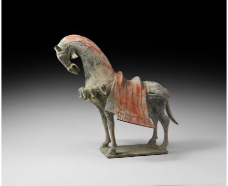 Northern Wei Dynasty, 534-550 AD. A ceramic figure of a horse standing on a small square base, neck arched and head held down