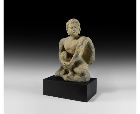 2nd-4th century AD. A substantial carved schist figure of Atlas crouching with wings folded to the rear, the head raised with