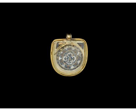 11th-12th century AD. A slender gold D-shaped pendant with enamelled spandrels to the upper angles, concentric rings of fine 