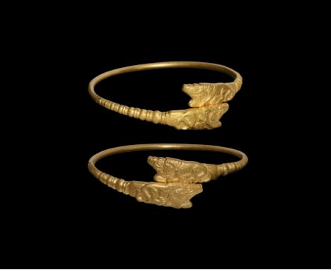 4th-2nd century BC. A gold penannular bracelet with ribbed shoulders, each finial modelled as a lion attacking an ibex in pro