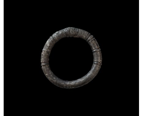 1st millennium BC. A substantial silver round-section bangle with hatched panels and biconvex collars.  559 grams, 11.5cm (4 