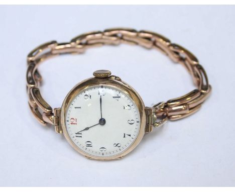 A ladies 1920s 9ct gold wristwatch, 28mm round case, white enamel dial with Arabic numerals, expanding 9ct gold bracelet, (wo
