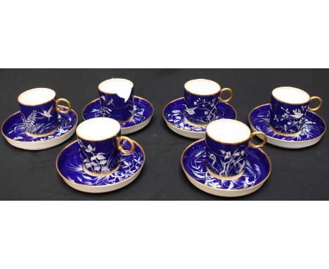 A set of six Victorian painted porcelain pate-sur-pate coffee cans and saucers, finely painted in white enamel with flowers, 