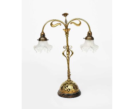 An Art Nouveau brass twin-light table lamp, domed, pierced base cast with flowers and foliage, central column with terminatin