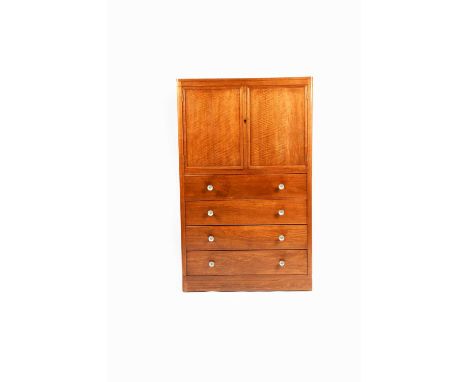 A Gordon Russell American walnut and ebony cupboard over chest, designed by W H Russell, made by P Wade, dated 1931, twin-doo