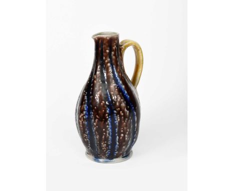 A Martin Brothers stoneware gourd jug by Robert Wallace Martin, the twisted body with applied loop handle, glazed aubergine, 
